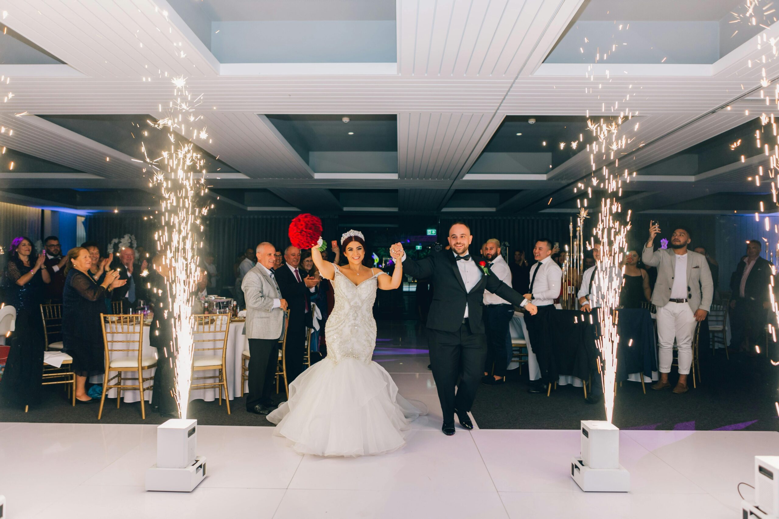 A joyful wedding reception with the newlyweds dancing amidst sparks and celebrations.